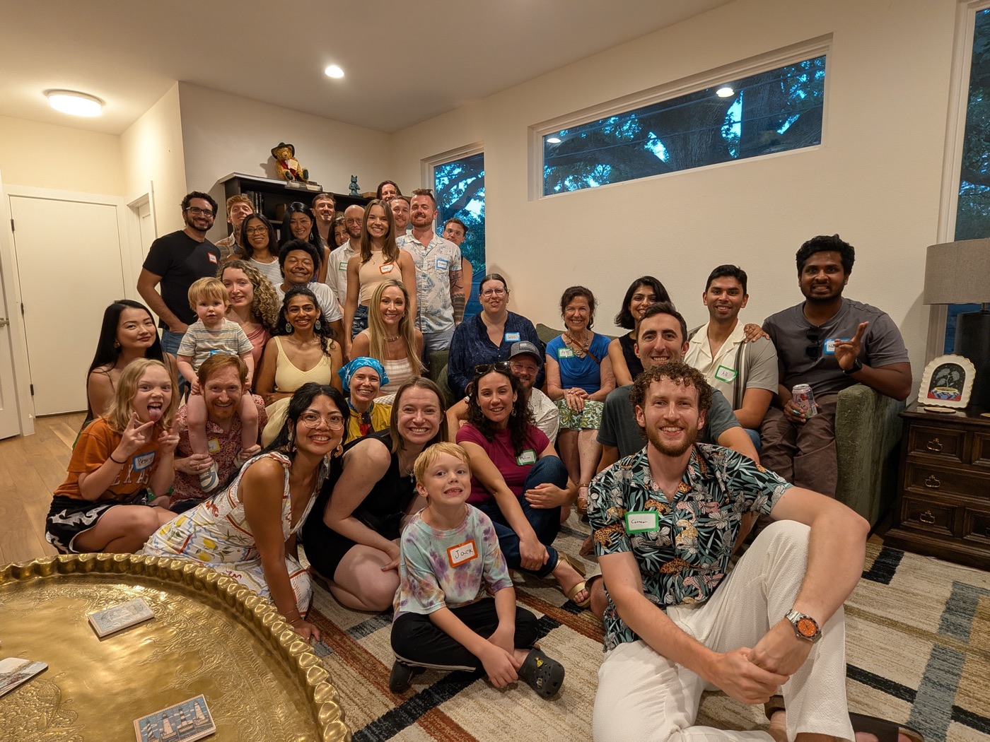 A living room full of party guests wearing name tags, Connor front and center
